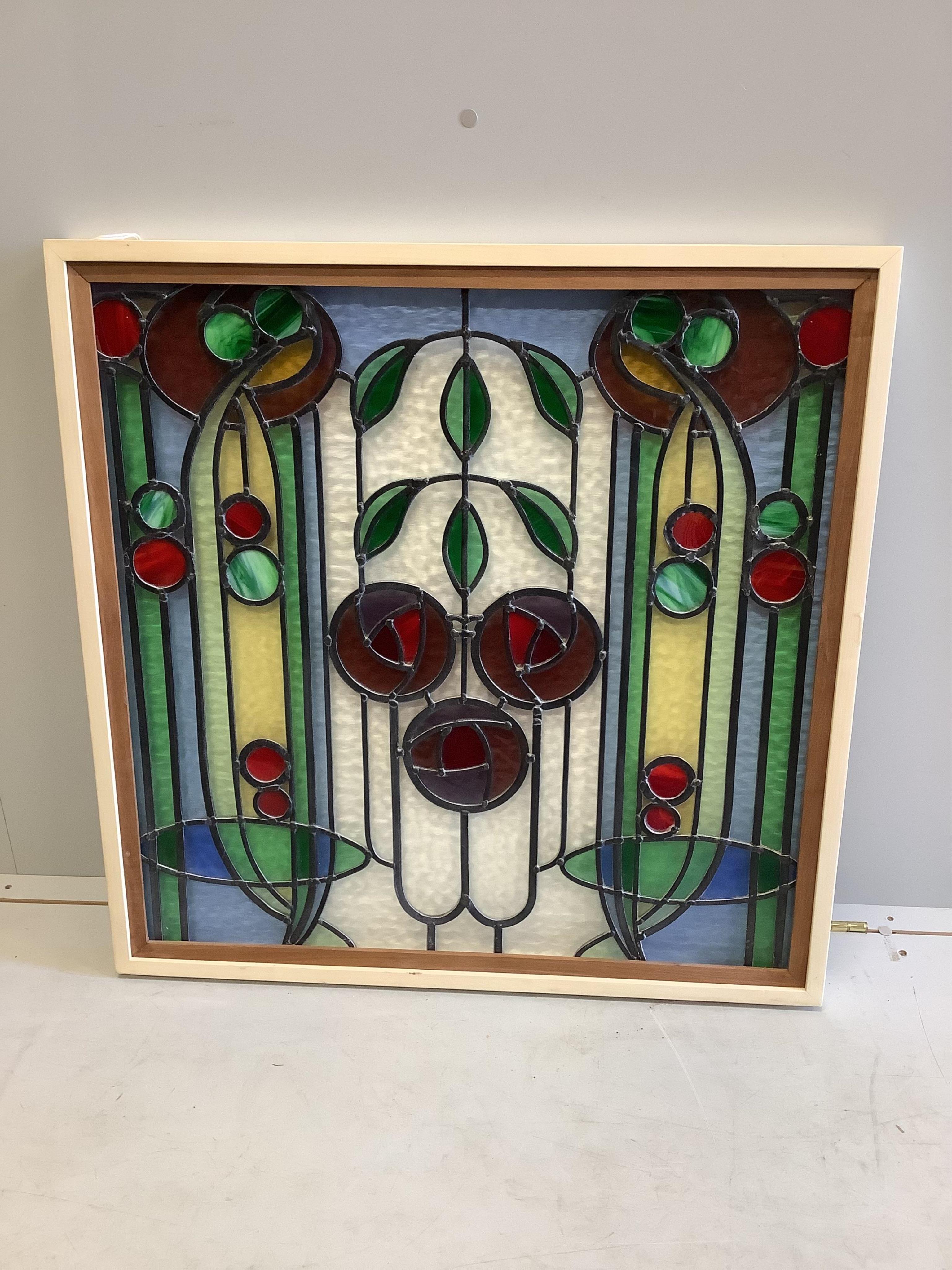 In the manner of McIntosh. A framed stained glass panel, width 79cm, height 79cm (including frame). Condition - good
